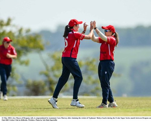 21 May 2023; Jess Mayes of Dragons, left, is congratulated by teammate Cara Murray after claiming the wicket of Typhoons' Robyn Searle during the Evoke Super Series match between Dragons and Typhoons at Oak Hill Cricket Club in Kilbride, Wicklow. Photo by Seb Daly/Sportsfile
